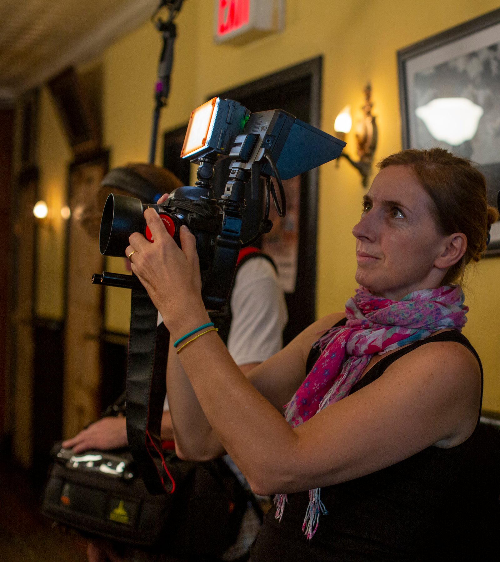 Simone Bueno holding a filmmaking camera with light and pulling focus.